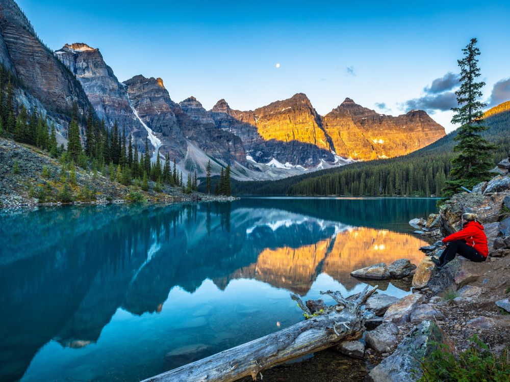 hiker admiring alaskan mountains from river bank