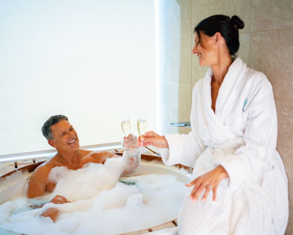 couple celebrating with champagne in hot tub