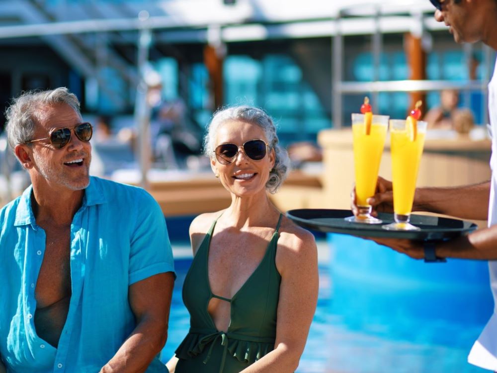 couple receiving poolside drinks