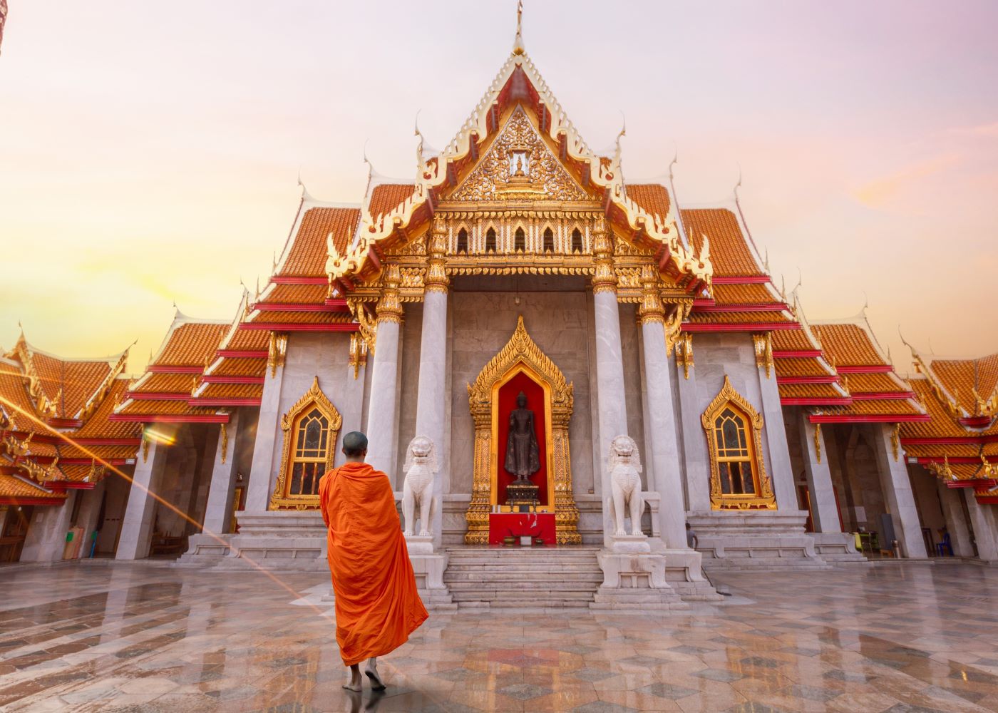 monk facing temple during sunset